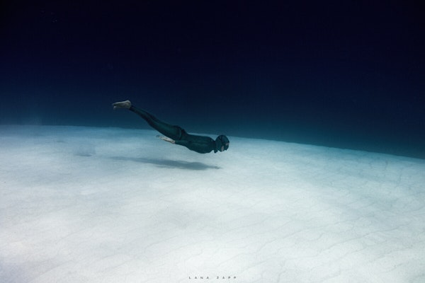 Freediver gliding over sand bank - Lana Zapp Photography