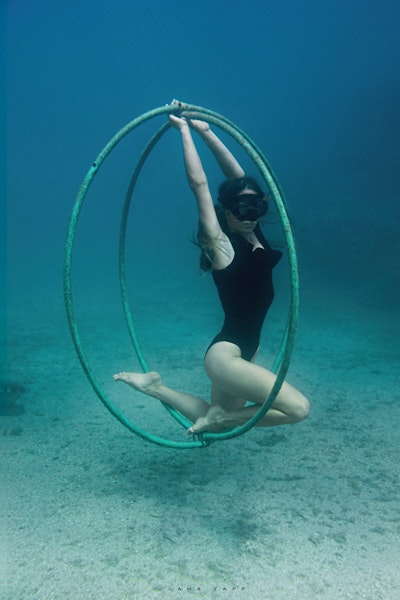 Freediver balancing rings underwater - Lana Zapp Photography