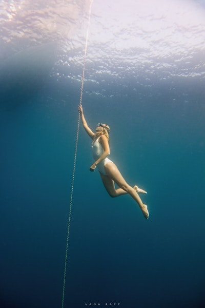 Freediver holding onto anchor chain - Lana Zapp Photography